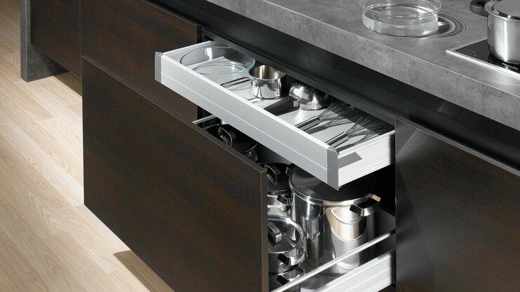 Detailaufnahme von Küchenschubladen Detailaufnahme von Küchenschubladen mit viel Stauraum in dunklem Holz