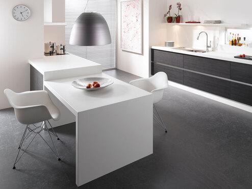 Impression einer Küchengestaltung mit Essplatz für Zwei Impression einer einzeiligen Küchengestaltung in schwarz-weiß mit Esstisch für Zwei