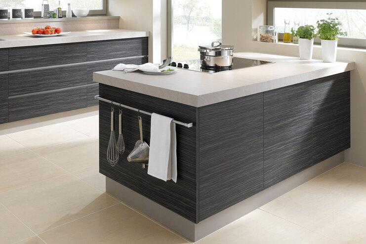 Impression einer Küchengestaltung mit Kochinsel Impression einer Küchengestaltung mit Kochinsel mit Edelstahlabzug und dunklen Fronten